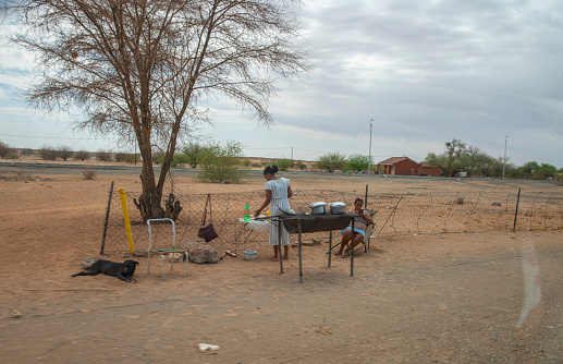African family cooking outside, next to the tree
