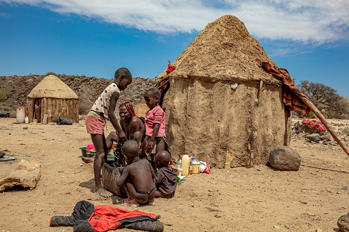 African tribal family in front of their hut