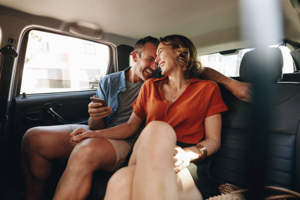 cheerful couple in rear seat of car - back seat imagens e fotografias de stock