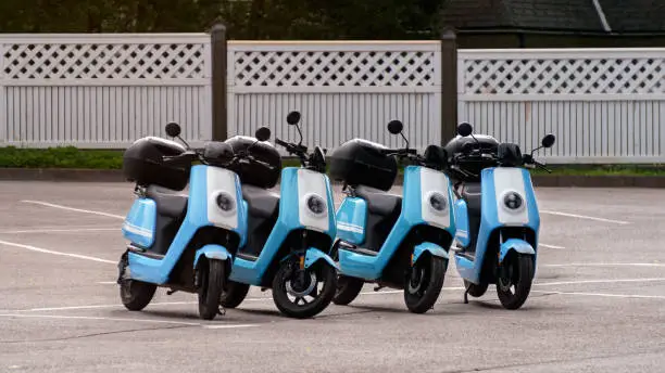 Photo of A row of four scooters for tourist rent.