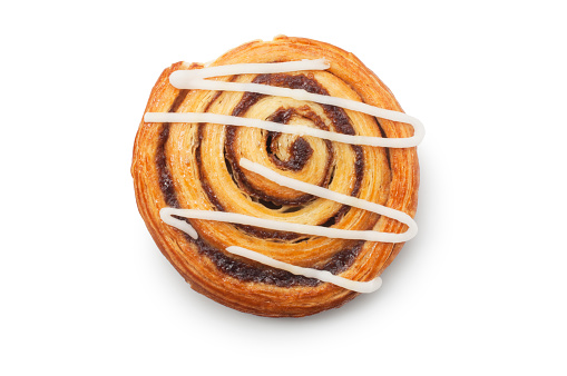 Studio shot of a cinnamon bun topped with icing cut out against a white background.