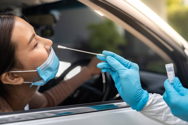 азиатская женщина drive thru covid-19 тестирования с медицинским персоналом сиз - specimen holder фотографии стоковые фото и изображения