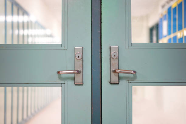 la escuela cerró debido al coronavirus. cierre de escuelas bajo la pandemia mundial covid-19. enfoque selectivo en la puerta y el mango con pasillo borroso, fondo del casillero. lucha contra las enfermedades de riesgo para la salud pública. - edificio escolar fotografías e imágenes de stock