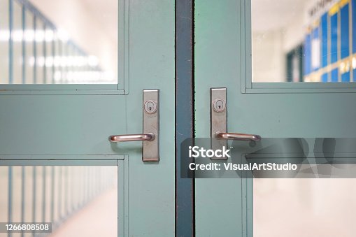istock School closed due to Coronavirus. School closure under COVID-19 global pandemic. Selective focus on door and handle with blurred hallway, locker background. Fight against public health risk disease. 1266808508
