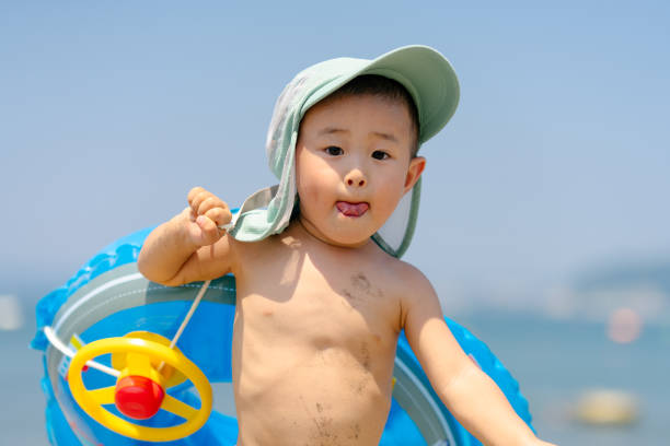 istock Small boy carrying swimming ring at beach 1266808558