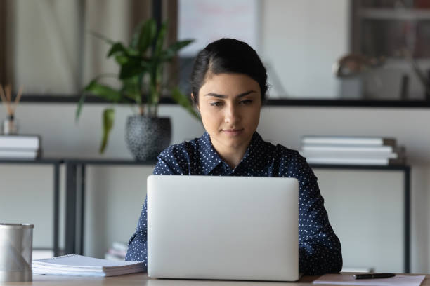 istock Focused young indian ethnicity businesswoman working on computer in office. 1266809673