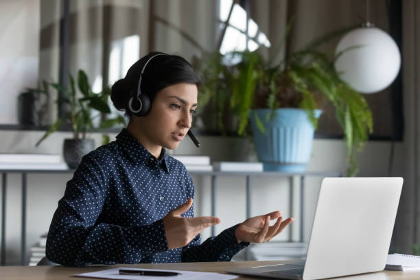 istock Serious mixed race woman involved in practicing foreign language online. 1266809679