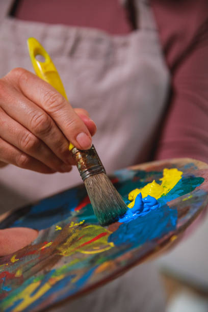 istock Woman mixing paints on artist's palette 1266809769