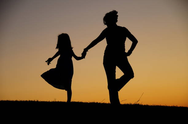 istock Mother and daughter dancing at dusk 1266809867
