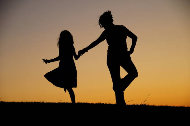 istock Mother and daughter dancing at dusk 1266809924