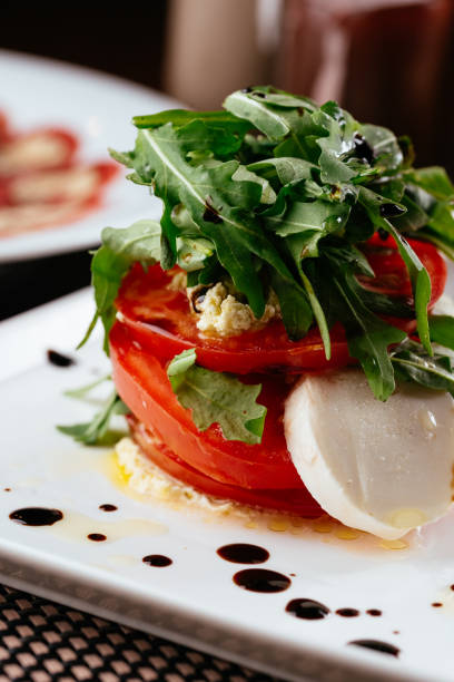 istock Caprese salad on a white plate and dark background 1266810050