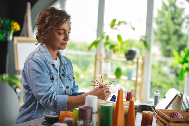istock Creative mature woman making candle decorations 1266810588