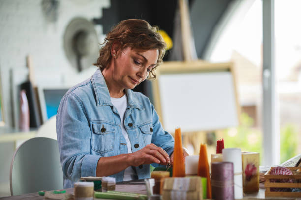 istock Mature woman concentrating while crafting candle decorations 1266810589