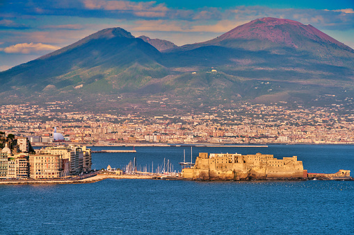 Beautiful sunrise over the Bay of Naples with the Castel dell'Ovo in front of the famous Mt. Vesuvio. The Castel dell' Ovo is the oldest standing fortification in Naples.