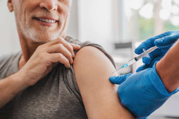 médico fazendo injeção para paciente sênior em clínica - syringe vaccination human hand medical procedure - fotografias e filmes do acervo