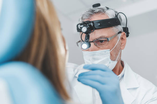 när du tittar på äldre läkare otolaryngologist undersöker vuxen kvinna för halsont - tonsill bildbanksfoton och bilder