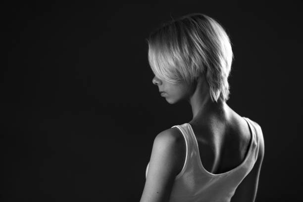 若い悲しい女性が目をそらす、暗い黒と白の写真。横に立つ. - teenager dark pensive emotional stress ストックフォトと画像