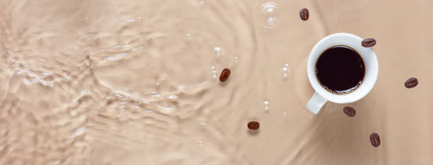 Hot coffee is splashing in cup. water and beans are blending