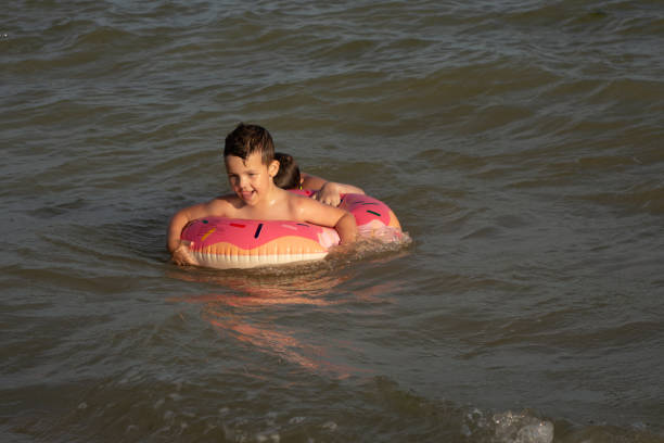 istock A 5-year-old boy bathes in a donut-shaped life ring on a sunny day. 1266817620
