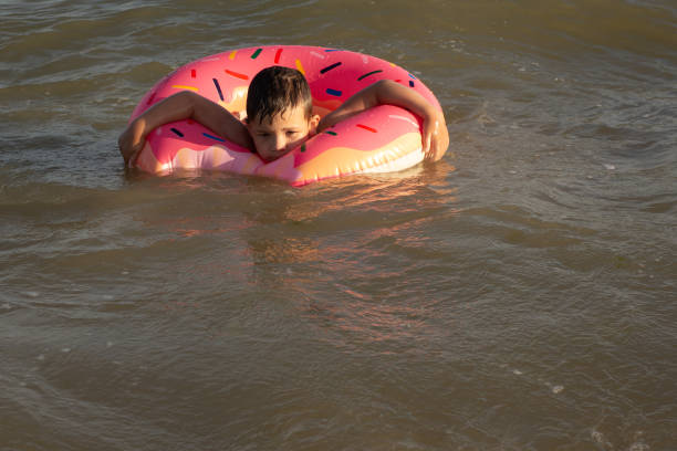 istock A 5-year-old boy bathes in a donut-shaped life ring on a sunny day. 1266817681