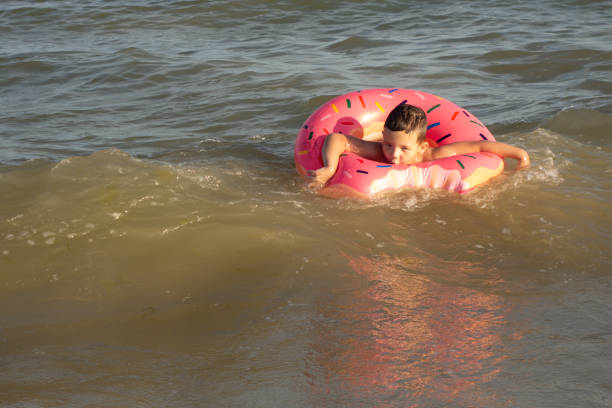 istock A 5-year-old boy bathes in a donut-shaped life ring on a sunny day. 1266817686