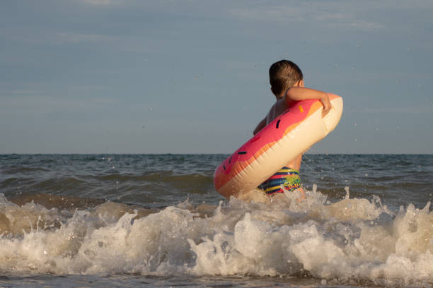 istock A 5-year-old boy bathes in a donut-shaped life ring on a sunny day. 1266817696