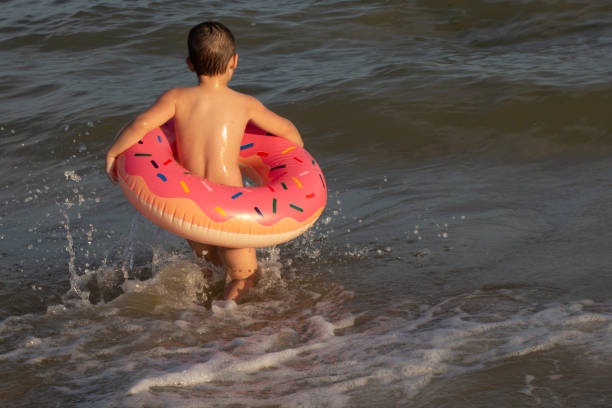 istock A 5-year-old boy bathes in a donut-shaped life ring on a sunny day. 1266817699