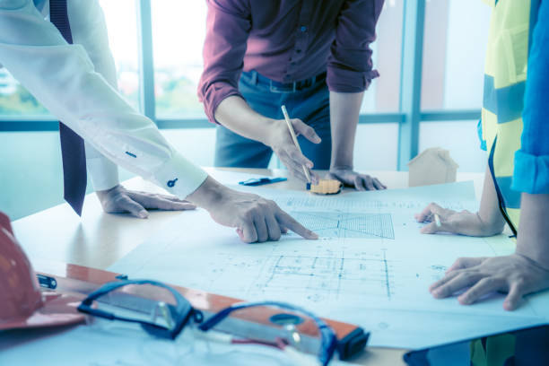 istock Construction team with business man engineer and architect is brainstorming on working table with building plan 1266817933