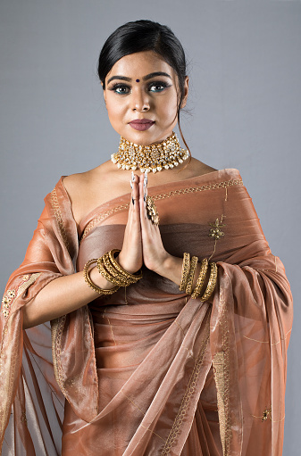Beautiful Indian woman in sari greeting with namaste gesture
