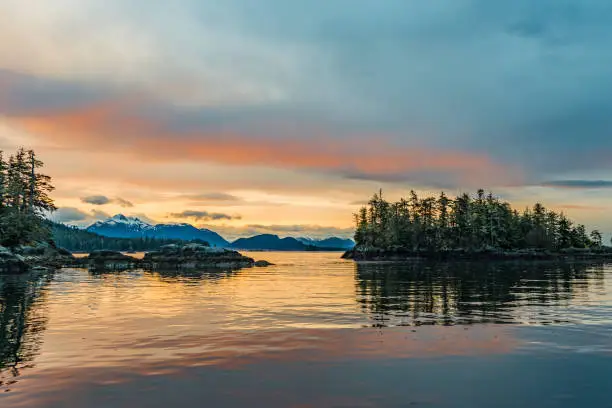 Sunset in Sitka Sound. With golden light reflection on the water between islands.