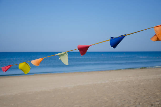 Color bunting flags on wind in summer sea camp.