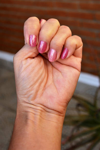 istock Hand showing pink painted nail with glitter 1266821541
