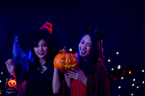 Asian women in witch costume in dark night forest scene. Halloween party concept.  party art design concept. new normal social distancing