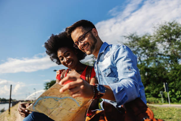 istock Young multiracial tourists sitting outdoors and exploring the map. 1266821947
