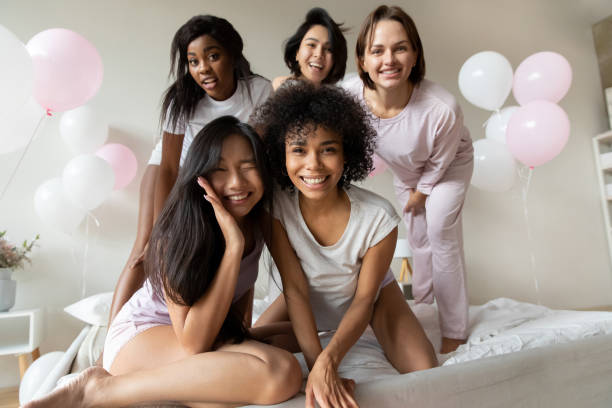 istock Diverse girls in pyjamas looking at camera having fun indoors 1266822043