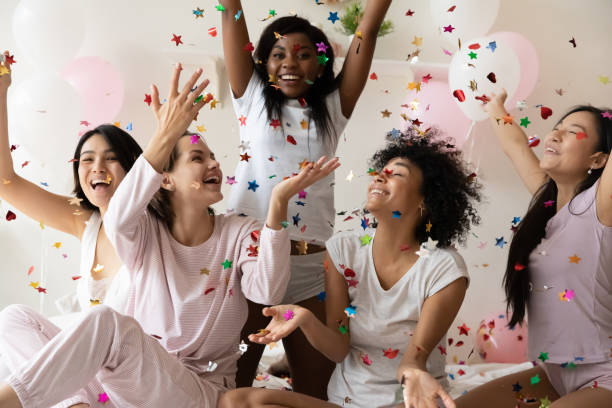 istock Multiethnic sexy young girls laughing catching falling multi colored confetti 1266822066