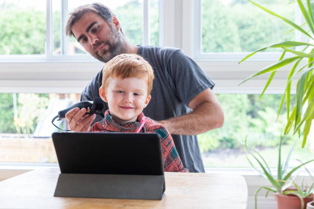 istock Father cutting his son's hair at home before going to school 1266822191
