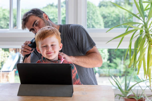 istock Father cutting his son's hair at home before going to school 1266822213