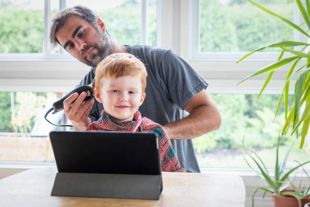 istock Father cutting his son's hair at home before going to school 1266822292