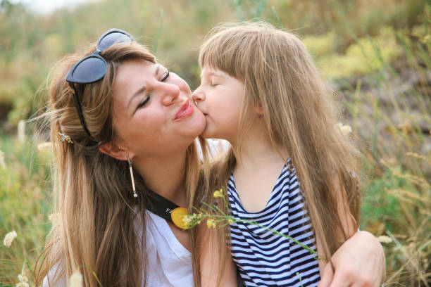 istock Joyful mom and daughter sit in the open air 1266823092