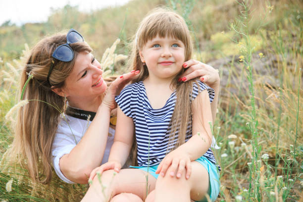 istock Joyful mom and daughter sit in the open air 1266823094