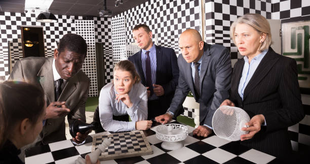 hommes d’affaires résolvant l’énigme ensemble près de l’échiquier - chess board room business strategy photos et images de collection