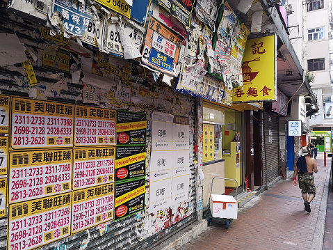 Advertisements in Yau Ma Tei, Kowloon Peninsula, Hong Kong. Man walking on the sidewalk.