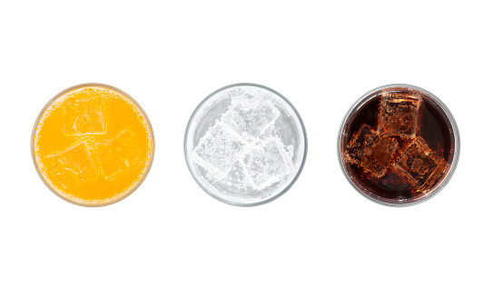 Top view of glasses of orange soda, lemon lime soda and cola drinks with ice isolated on white