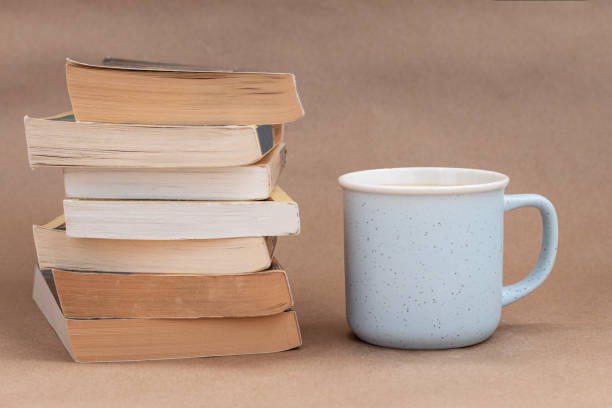 istock stack of old book with a cup of coffee or tea, beige background 1266832010