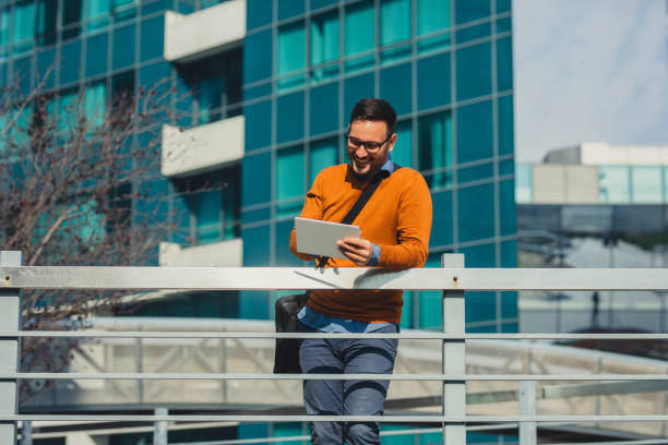 istock Happy Handsome Businessman Using a Digital Tablet in front of an Office Building, Connected on the Go Concept 1266833908