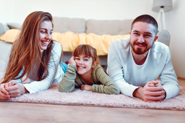 istock Three Siblings Enjoying Relaxing On The Floor Together 1266834787