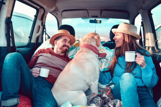 istock Couple Drinking Tea And Enjoying Read Trip With Dog 1266835160