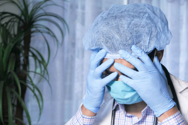 istock Depressed sad matured doctor covering face with hands 1266835223