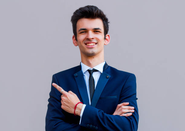 istock Young handsome businessman with beaming smile pointing with finger 1266835916